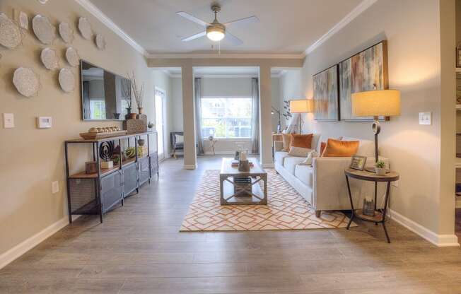 Spacious living area with wood-designed flooring and large windows at Lullwater at Blair Stone apartments for rent