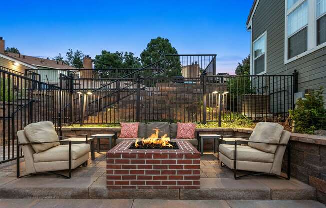 a brick patio with a fireplace and chairs at Apartments at Arcadia Apartments, Centennial, CO