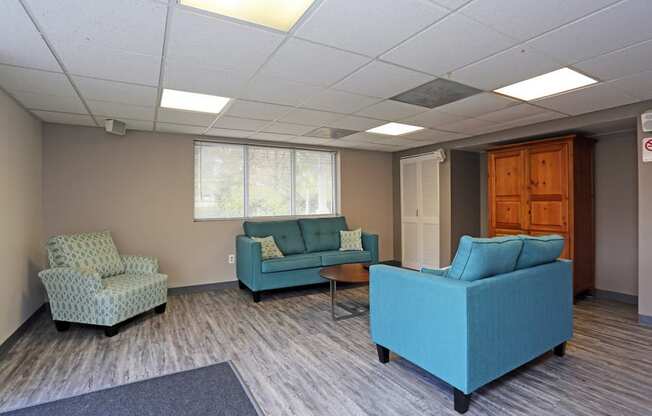 a waiting room with blue couches and chairs