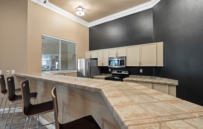 a kitchen with a long counter and chairs