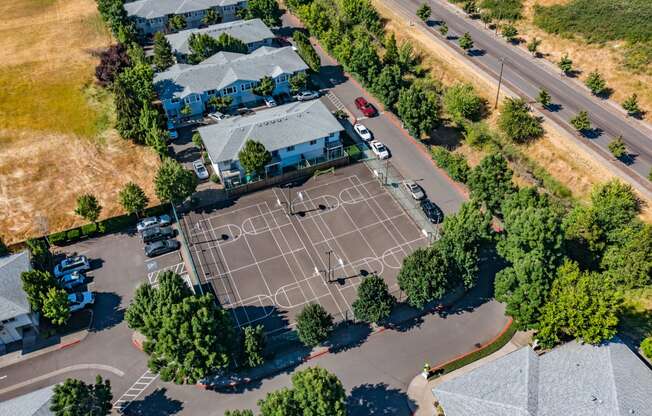 an aerial view of a tennis court in a residential neighborhood