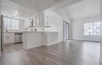 an empty kitchen and living room with a large window  at The Resort at Encinitas Luxury Apartment Homes, Encinitas, CA