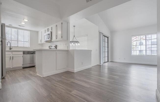 an empty kitchen and living room with a large window  at The Resort at Encinitas Luxury Apartment Homes, Encinitas, CA