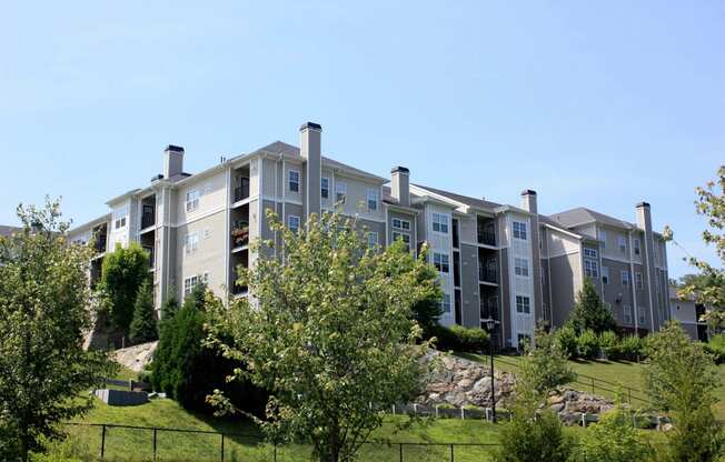 an apartment building on a hill with trees