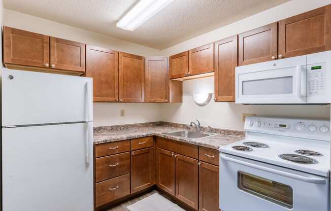 a kitchen with white appliances and wooden cabinets. Fargo, ND Parkwood