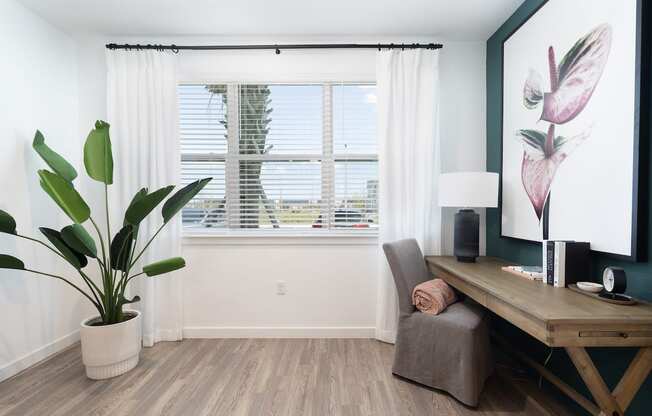 solarium with a large window, wood-style floors, and model decor