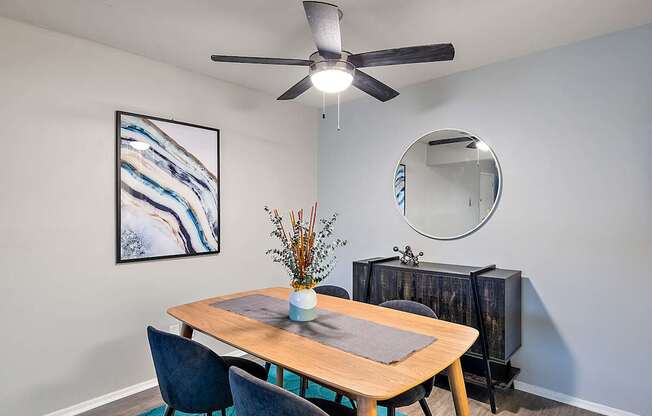A dining room with a wooden table and chairs.