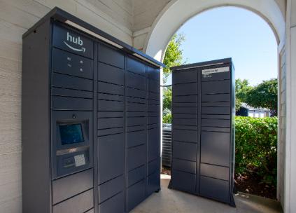 Two dark grey Amazon Hub kiosks are situated under an arched structure.