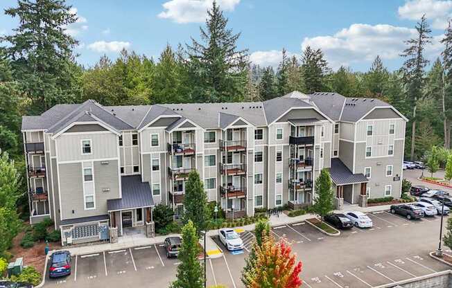 A large apartment complex with a parking lot in front.