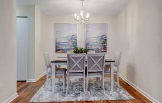 A dining room with a table set for four.