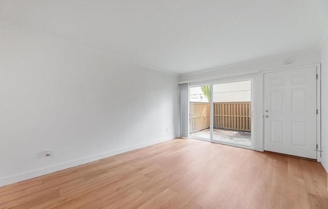 A room with wooden flooring and white walls.