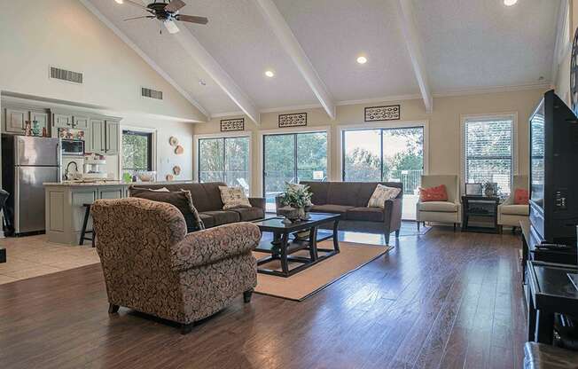 a large living room with couches and a table in the community club house