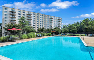 a swimming pool with an apartment building in the background