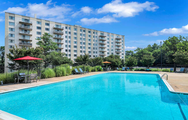 a swimming pool with an apartment building in the background