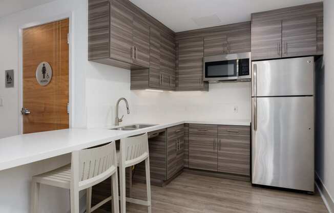 a kitchen with a white counter top and a stainless steel refrigerator