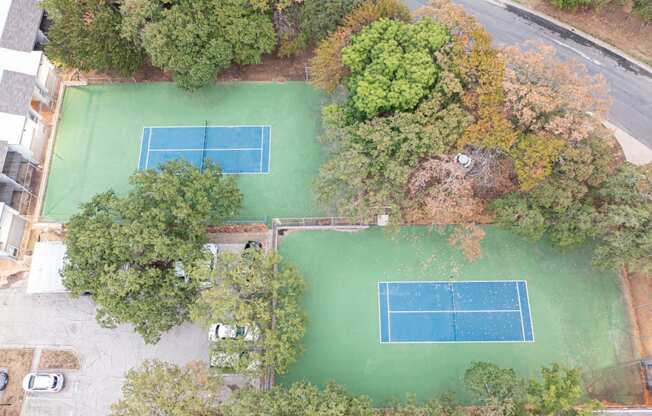 a birds eye view of a tennis court with trees