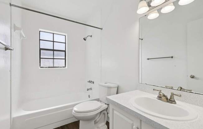 A white bathroom with a toilet, sink, and bathtub.