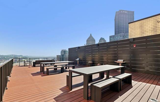 A rooftop patio with wooden flooring and furniture.