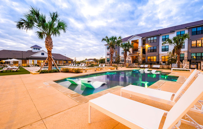 Swimming pool with two white chairs and a building in the background at The Parker Austin, Texas