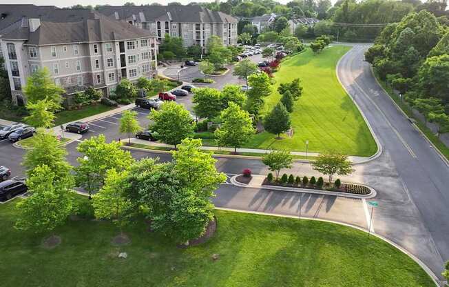 A road with a grassy median and apartment buildings on either side.