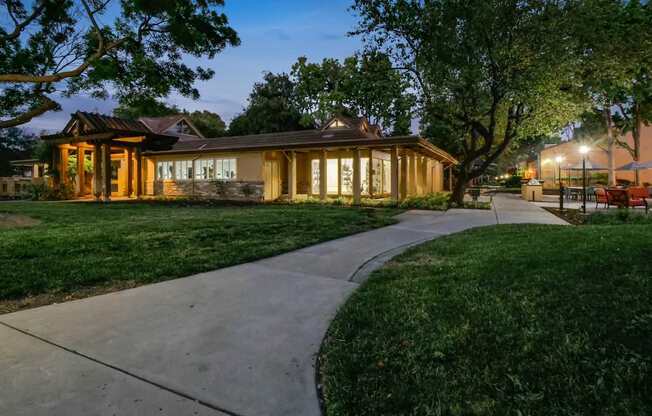 the house is lit up at night with the sidewalk in front of it at Summerwood Apartments, Santa Clara, California