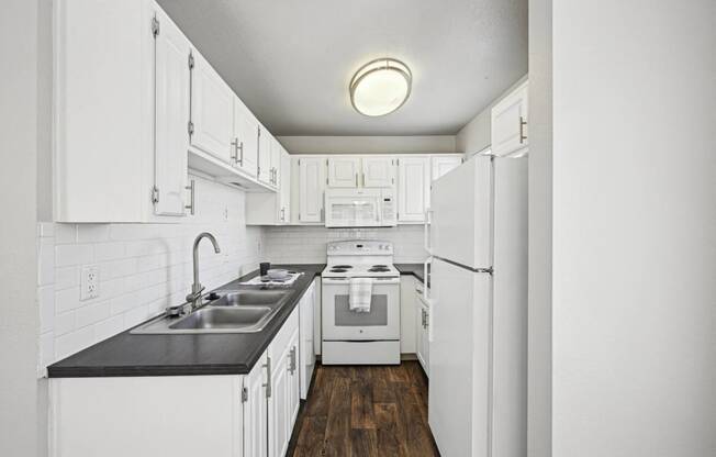 a white kitchen with white appliances and white cabinets