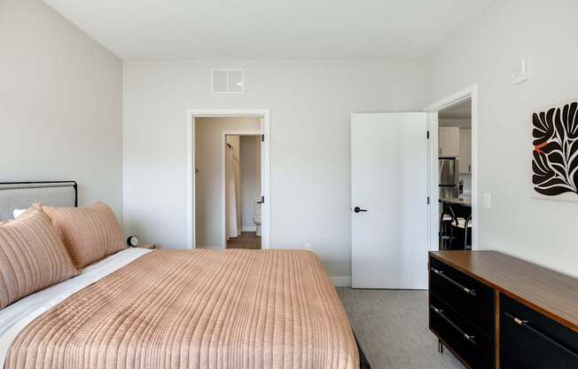 A bedroom with a large bed and a dresser.