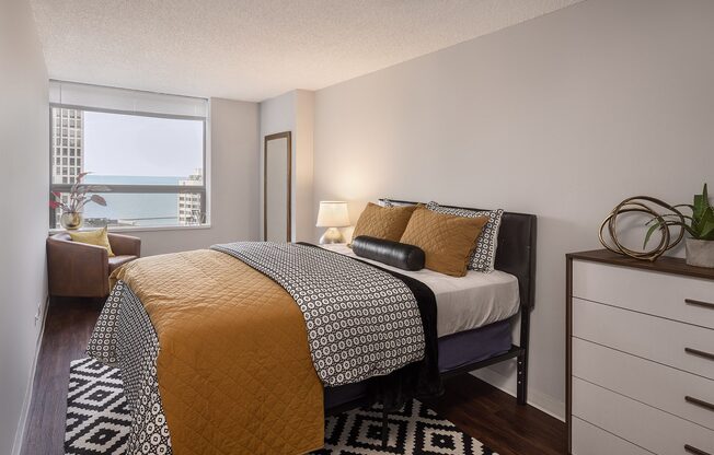 A bedroom with a bed covered in a yellow and black comforter.