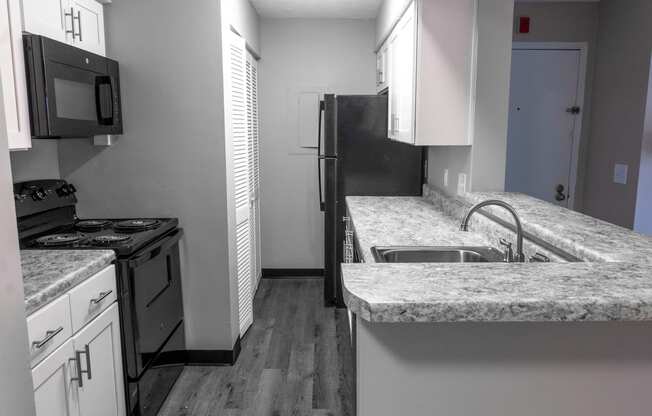 an empty kitchen with granite counter tops and stainless steel appliances