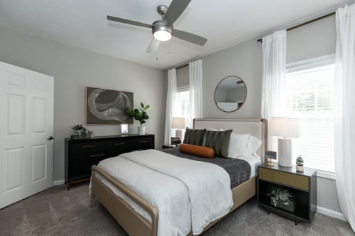 a bedroom with a bed and a ceiling fan