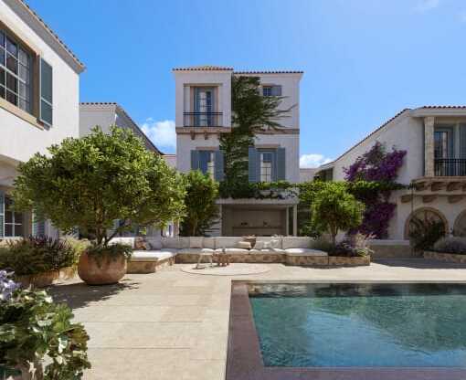 a courtyard with a pool and a house in the background