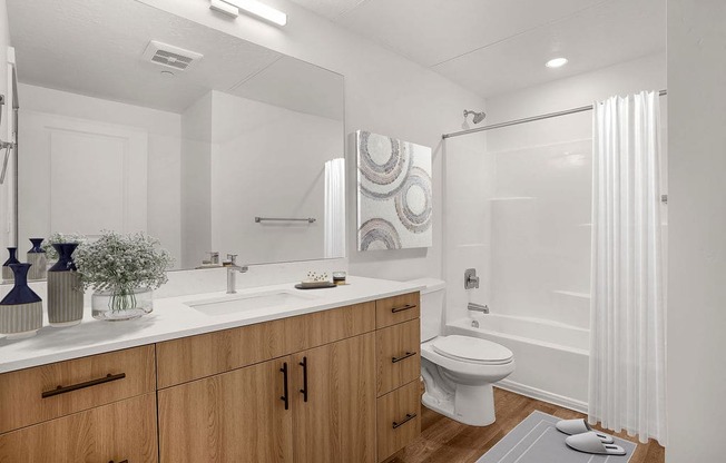 A bathroom with a white toilet, sink, and shower.