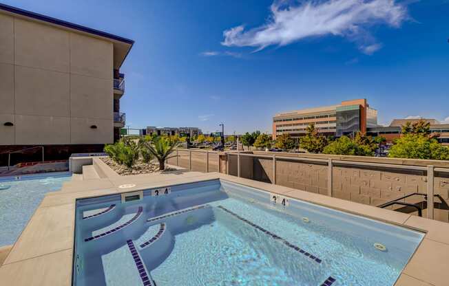 pool on the rooftop of a building with a city in the background