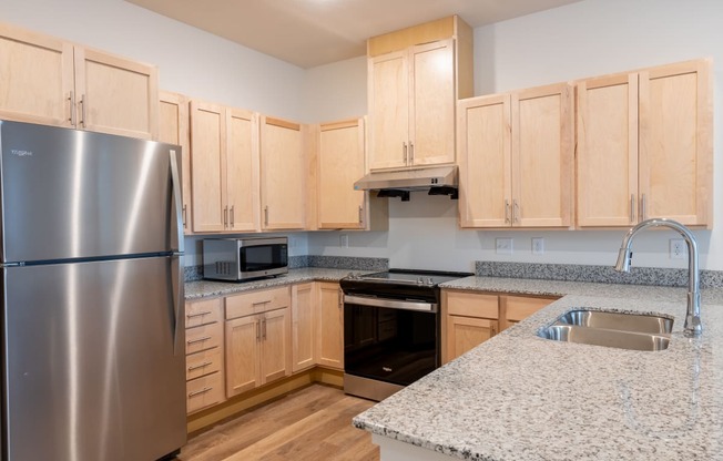 a kitchen with granite counter tops and wooden cabinets