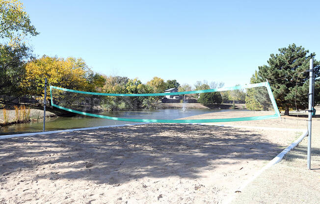 beach volleyball court alongside stocked fishing pond