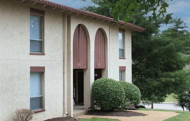 a building with three windows and a walkway in front of it