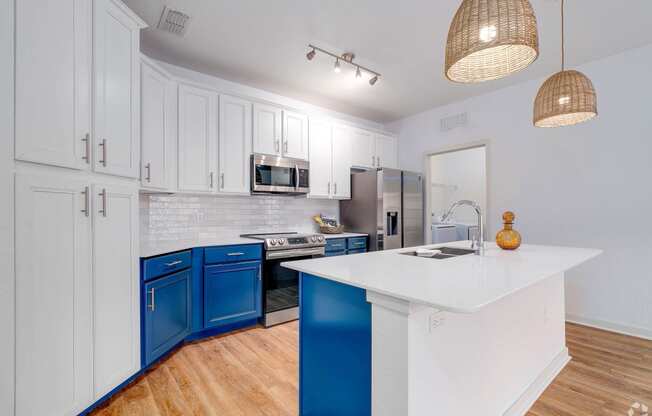 a kitchen with blue and white cabinets and a white counter top