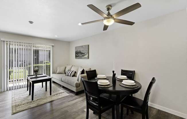 Spacious Open Space Living Room with Plank Flooring, Sliding Glass Door, and Overhead Ceiling Fan at Pinewood Square Apartment Homes, WA 98087
