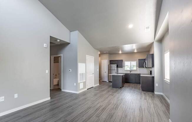 A spacious living area with a kitchen in the background.