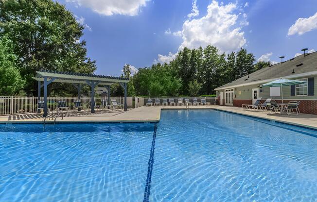 Swimming pool with covered deck seating at Ashley Oaks Apartments in Greensboro, North Carolina