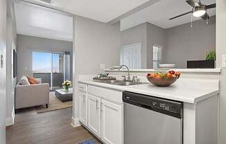A modern kitchen with a large island and a bowl of fruit on the counter.