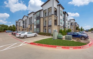 A white car is parked in a parking lot in front of a building.