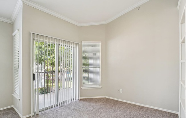A room with a sliding glass door and a carpeted floor.