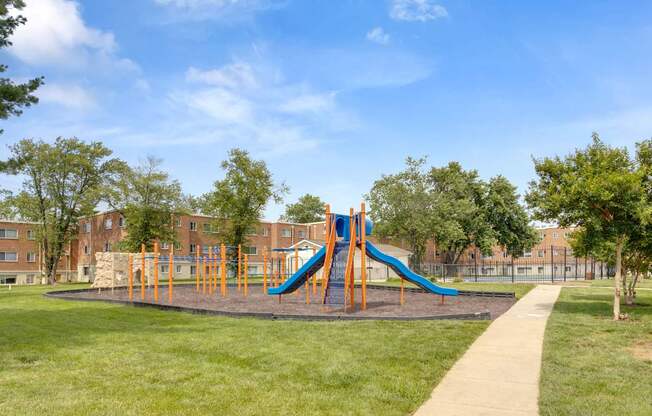 A playground with a blue and orange slide.