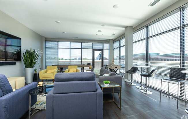 a living room with blue couches and chairs and a large window with a view