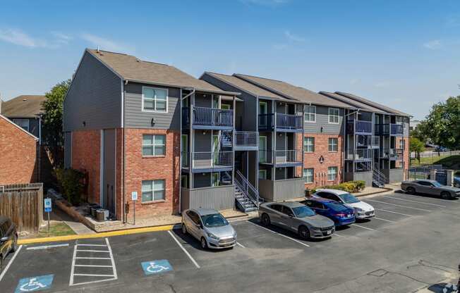 an apartment building with cars parked in a parking lot