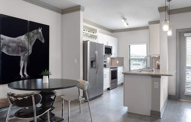 A modern kitchen with a black and white horse picture on the wall.