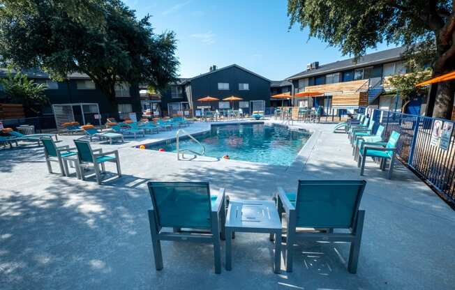 Apartments for Rent Arlington - Stadium 700 - Swimming Pool Surrounded By Lounge Chairs and Dining Areas with Orange Umbrellas