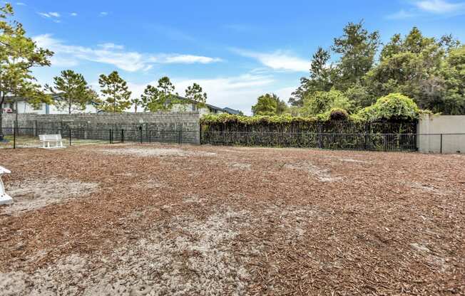 an empty yard with a fence and a bench