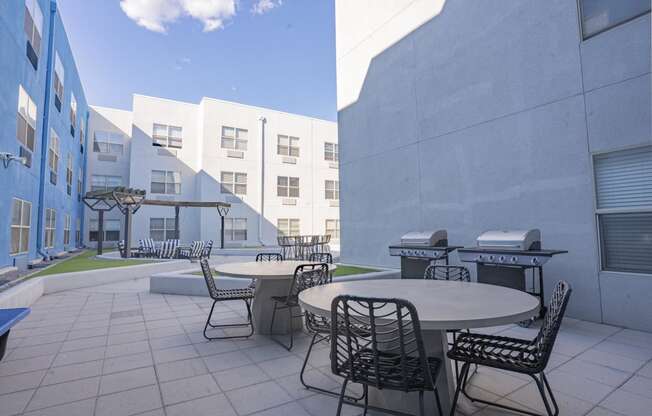 a patio with tables and chairs in a courtyard